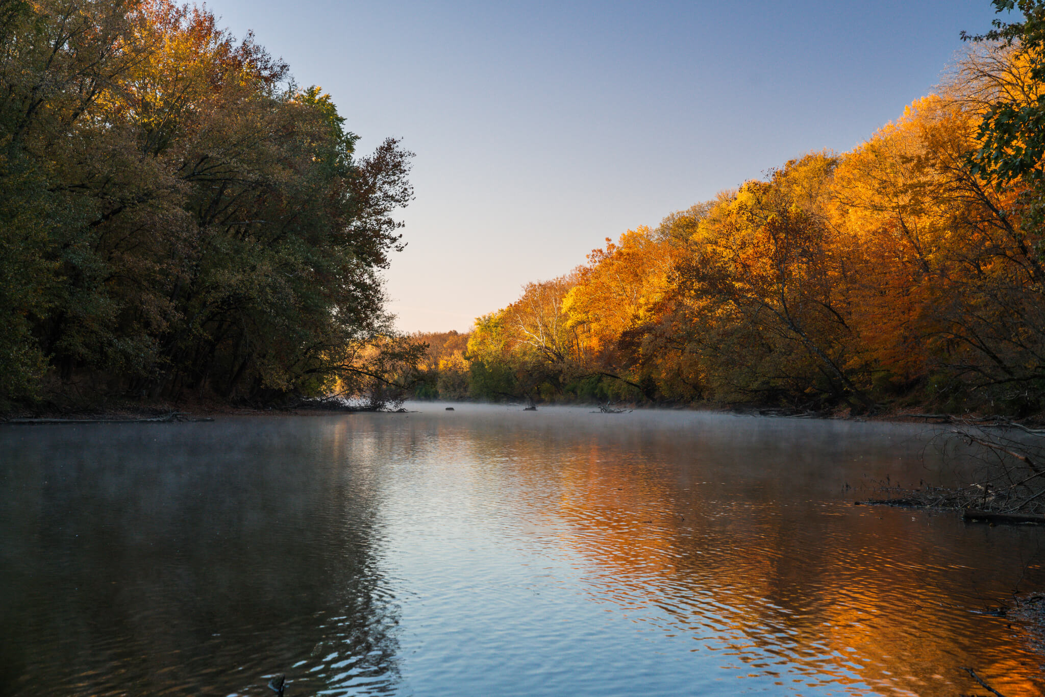 View looking down the White River with colorful orange and yellow autumn trees along its banks.