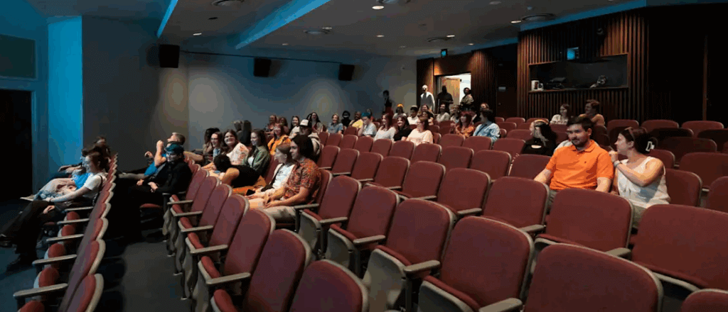 attendees sitting in theater seats