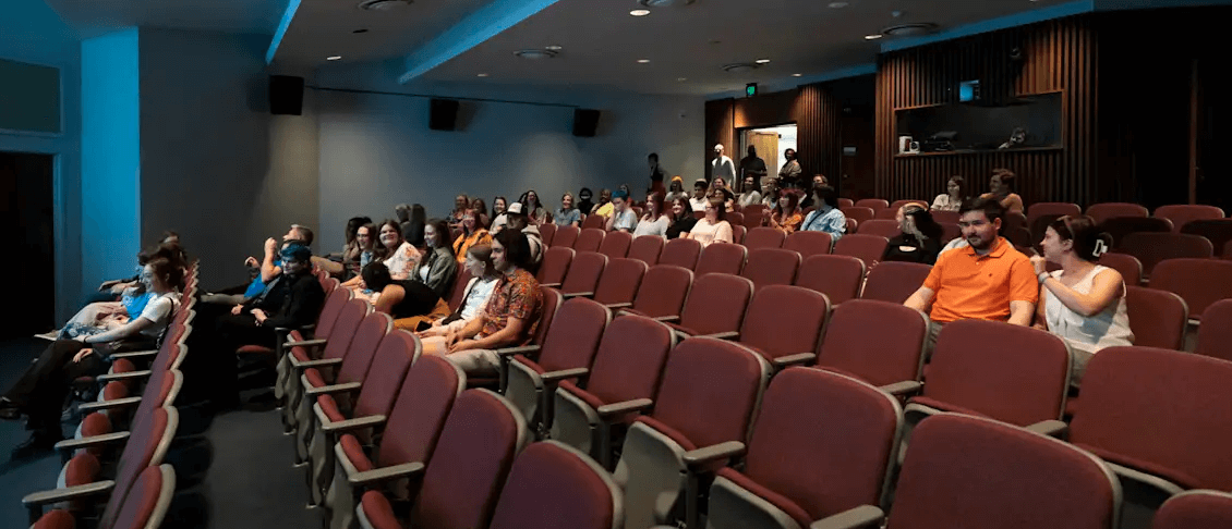 attendees sitting in theater seats