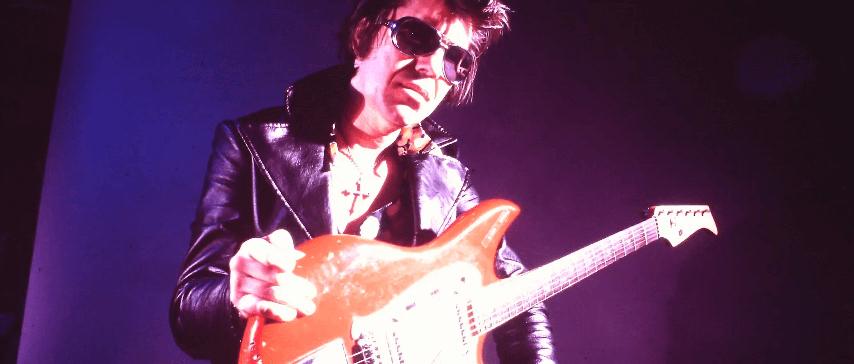 image of singer holding a guitar