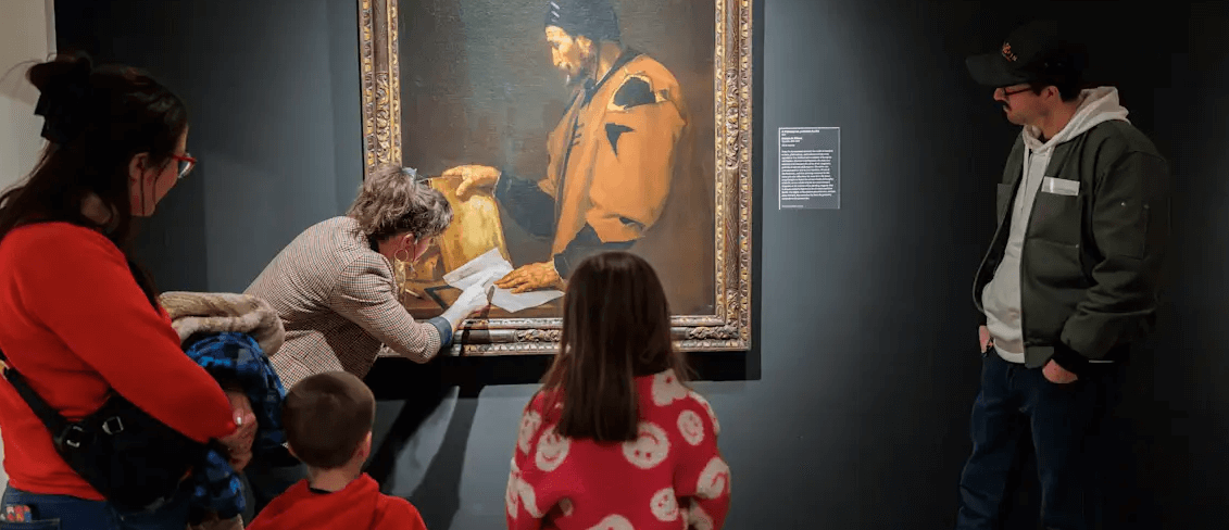 children and adults looking at a painting on the wall