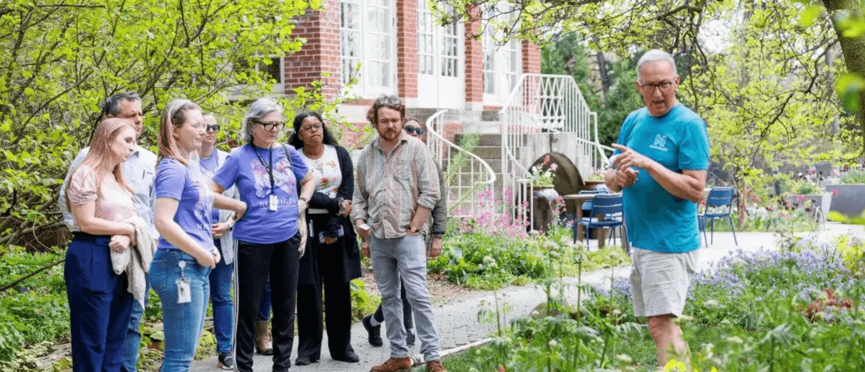 group of people listening to a man in the garden