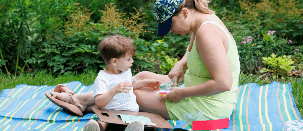 child with mother sitting on a picnic blanket
