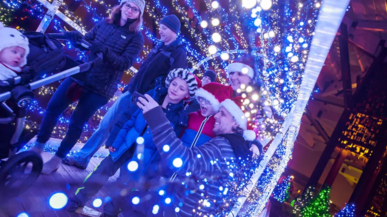Family taking picture around Christmas lights