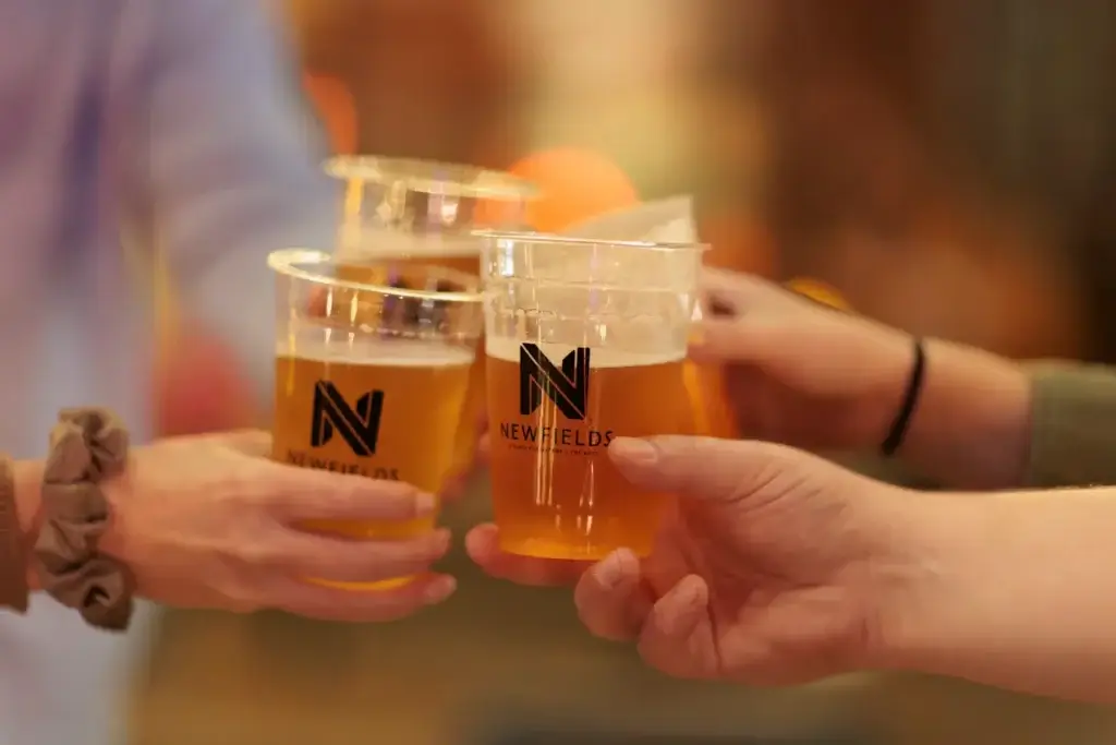 4 people tapping drinks together