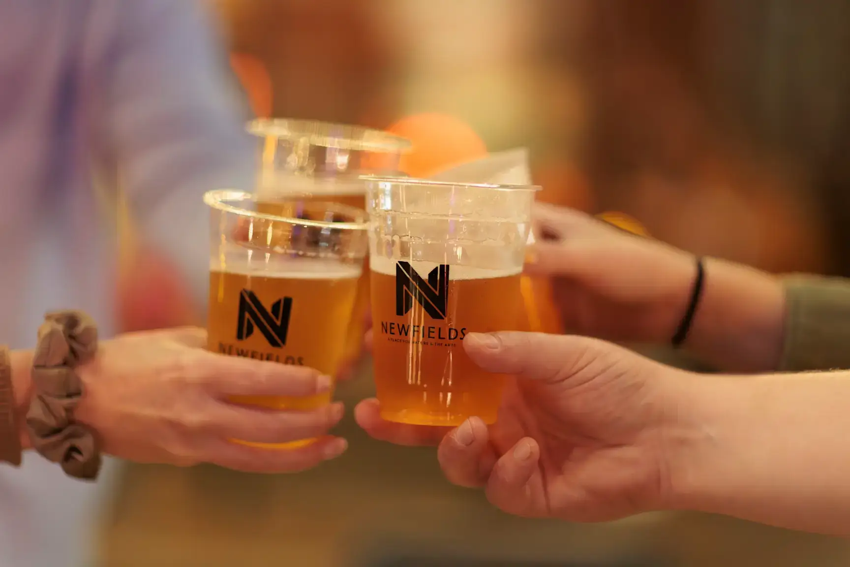 4 people tapping drinks together